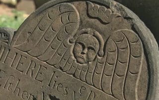 Close up of a Victorian-era gravestone with an angel carving